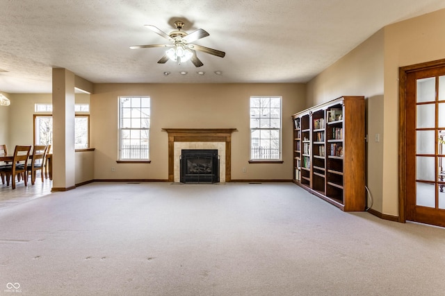 unfurnished living room featuring baseboards, light carpet, a textured ceiling, and a fireplace