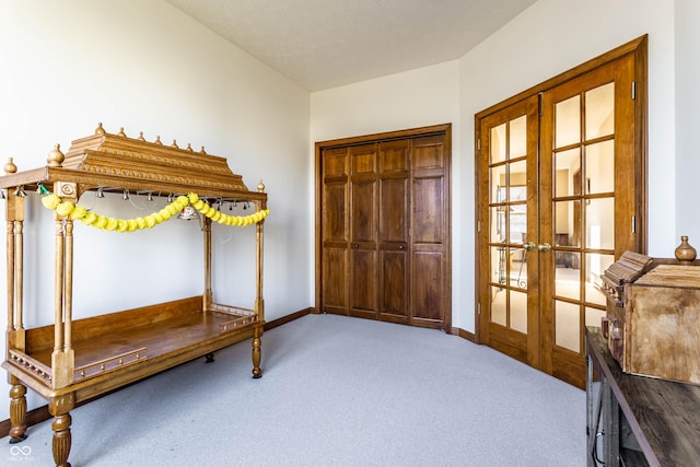 unfurnished bedroom featuring carpet flooring, french doors, and baseboards