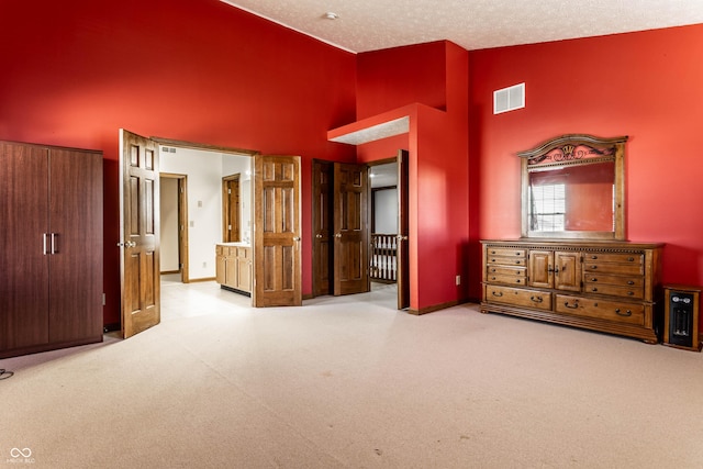 unfurnished bedroom with visible vents, high vaulted ceiling, a textured ceiling, carpet flooring, and baseboards