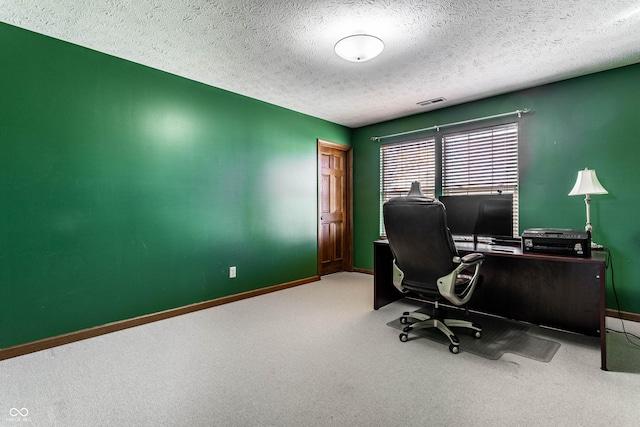 office area featuring carpet flooring, visible vents, baseboards, and a textured ceiling