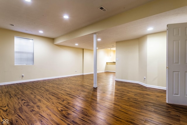 finished below grade area featuring recessed lighting, visible vents, baseboards, and dark wood-style floors