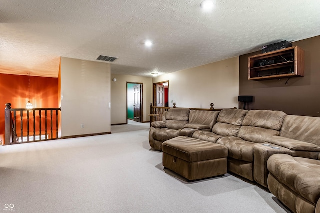 living area with visible vents, baseboards, carpet, and a textured ceiling