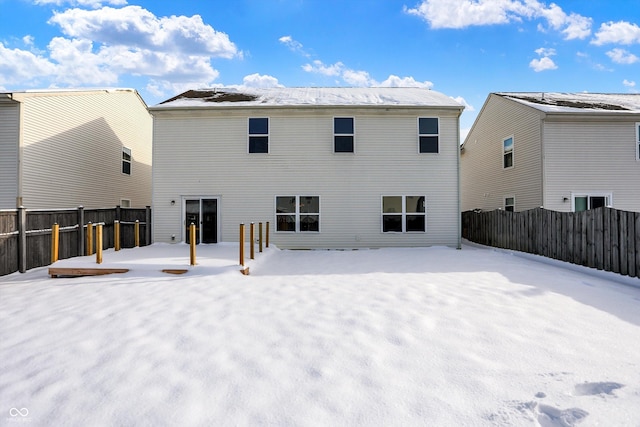 view of snow covered back of property