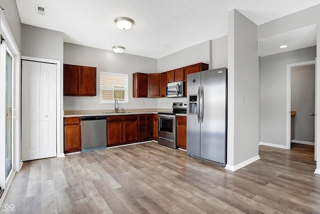 kitchen featuring sink, stainless steel appliances, and light hardwood / wood-style floors