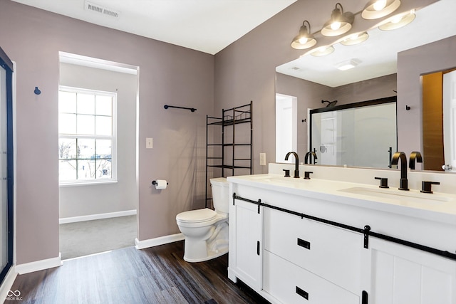 bathroom with toilet, vanity, wood-type flooring, and walk in shower