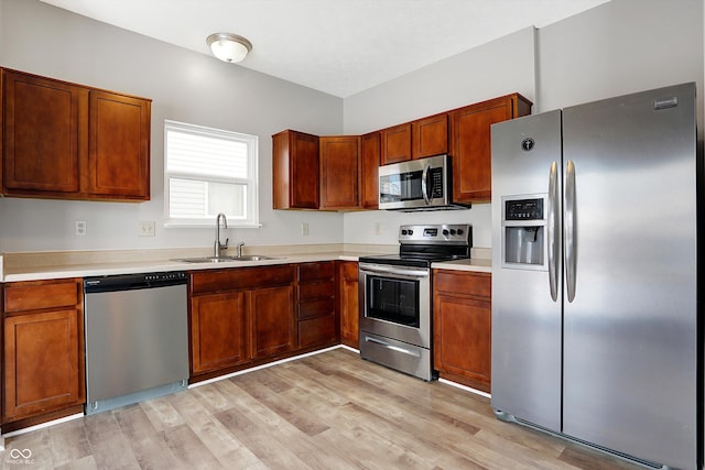 kitchen featuring sink, appliances with stainless steel finishes, and light hardwood / wood-style flooring