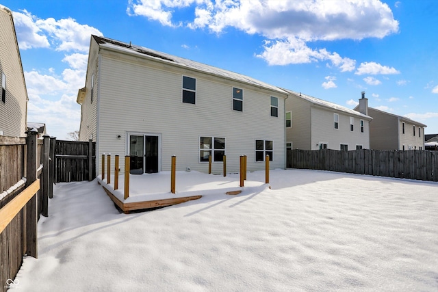 snow covered rear of property featuring a deck