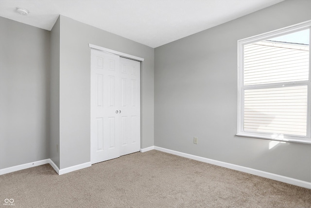 unfurnished bedroom featuring carpet and a closet