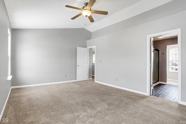 unfurnished room with ceiling fan, dark carpet, and lofted ceiling