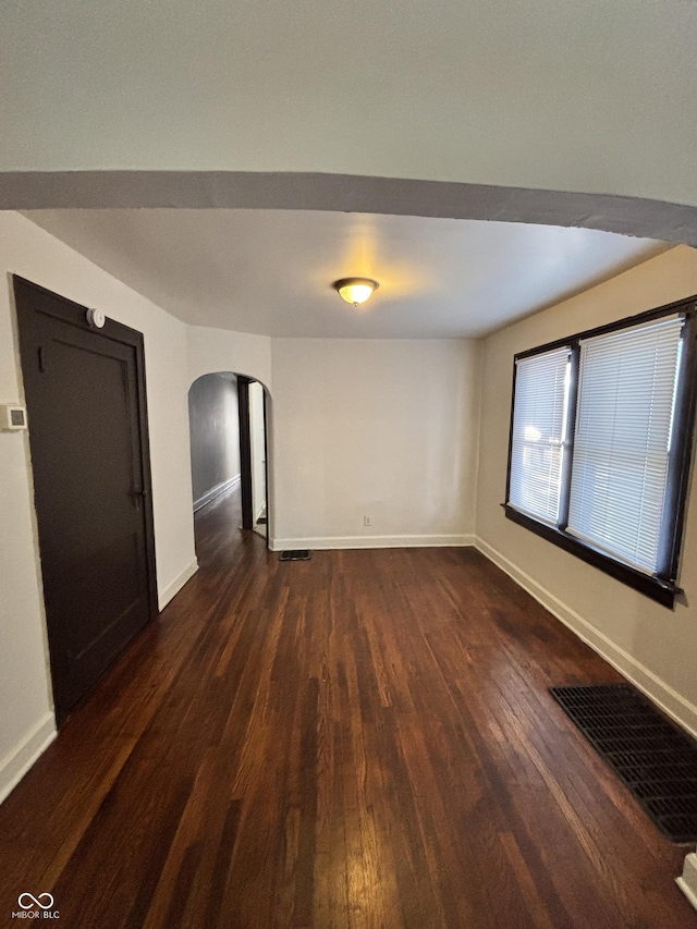 spare room with dark wood-type flooring