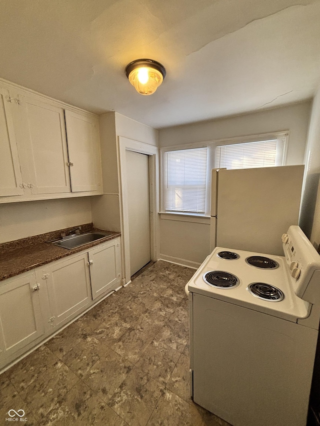 kitchen featuring white cabinets, white appliances, sink, and a wealth of natural light