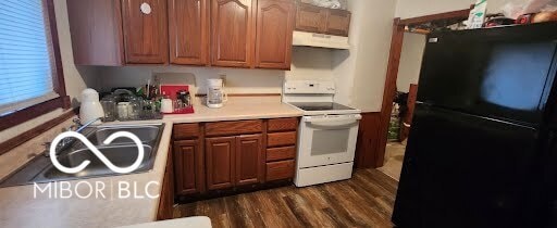 kitchen with black refrigerator, sink, dark wood-type flooring, and electric stove