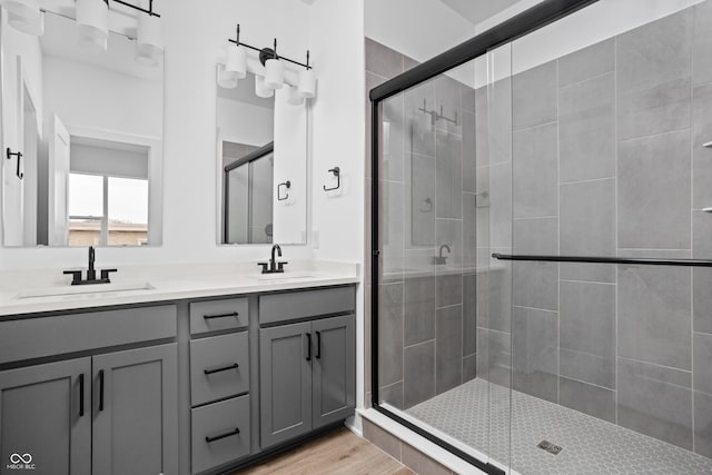 bathroom featuring hardwood / wood-style floors, vanity, and a shower with door