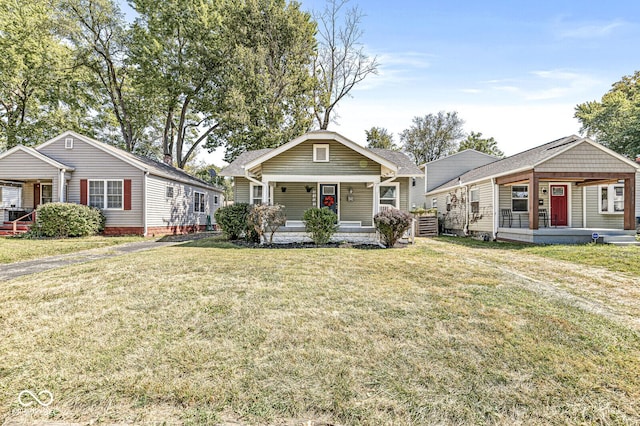 bungalow with covered porch and a front yard