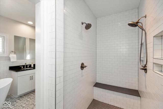 bathroom featuring plus walk in shower, vanity, tasteful backsplash, and tile walls