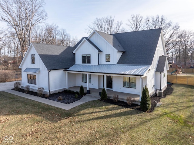 modern farmhouse featuring central air condition unit, covered porch, and a front yard