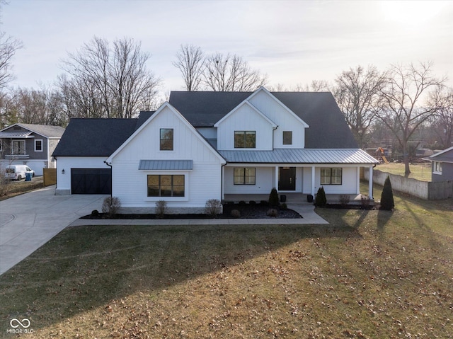 modern farmhouse featuring a porch, a garage, and a front lawn