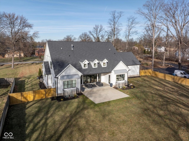 back of property with a lawn and a patio