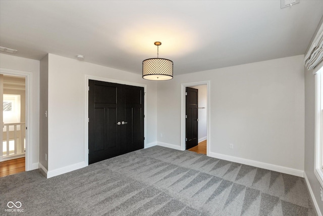 unfurnished bedroom featuring a closet and dark carpet