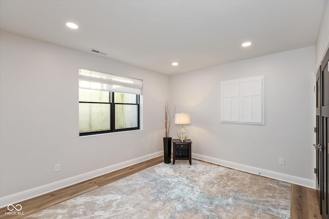 unfurnished room with wood-type flooring