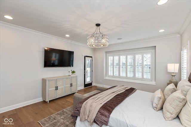 bedroom featuring hardwood / wood-style floors, crown molding, and a notable chandelier