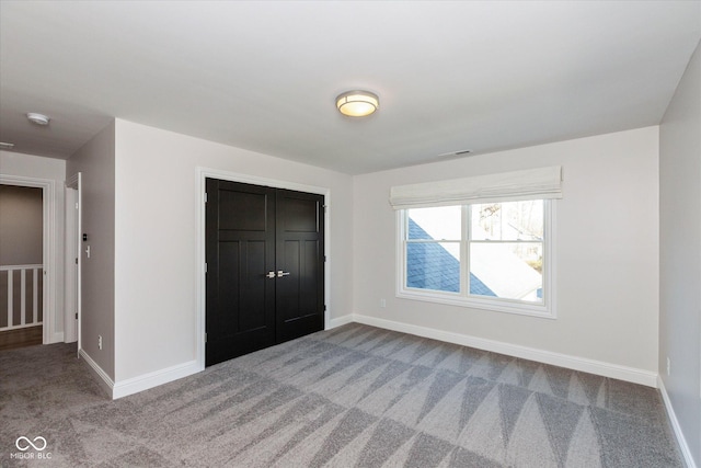 unfurnished bedroom featuring carpet flooring and a closet