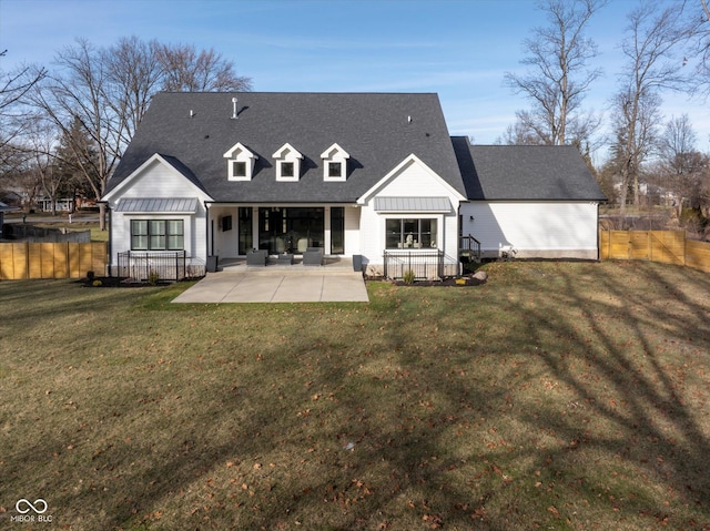 rear view of property featuring a lawn and a patio area