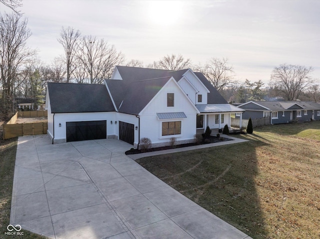 modern farmhouse style home with a front yard and a garage