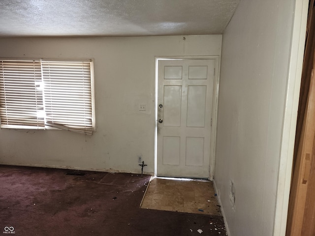 foyer entrance with a textured ceiling