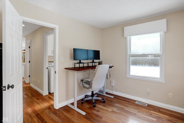 office area with washer / dryer and hardwood / wood-style flooring