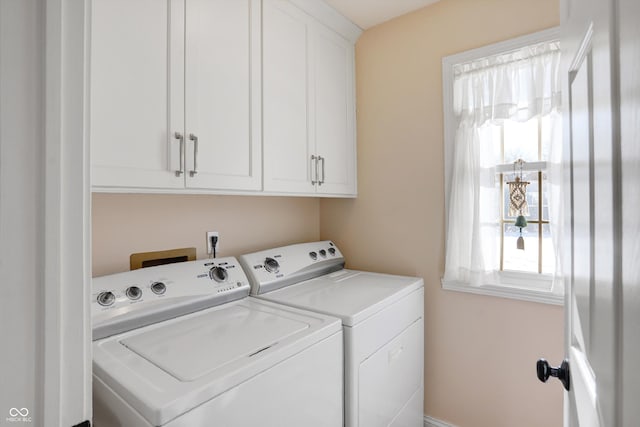 laundry room with cabinets, washer and clothes dryer, and plenty of natural light