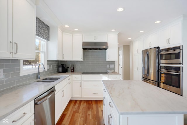 kitchen featuring stainless steel appliances, extractor fan, and white cabinets