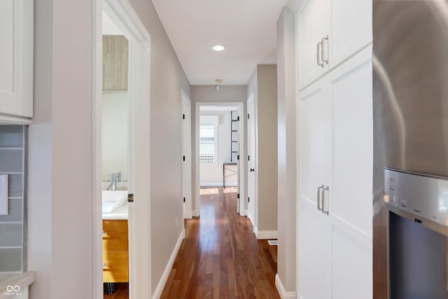 hallway with dark wood-type flooring and sink