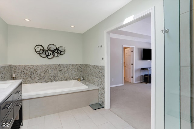 bathroom featuring vanity, tile patterned floors, and a relaxing tiled tub