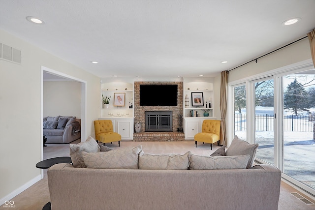 living room featuring a brick fireplace and built in features