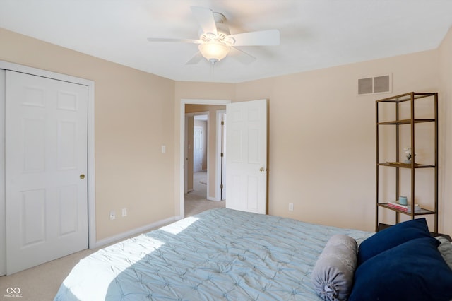 bedroom with ceiling fan, a closet, and light carpet