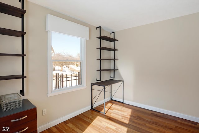 unfurnished room with a healthy amount of sunlight and hardwood / wood-style floors