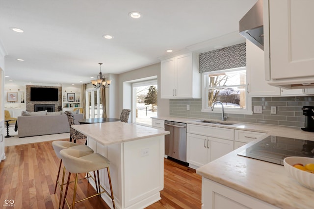 kitchen with white cabinets, dishwasher, sink, and a kitchen island