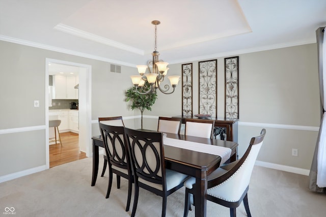 dining space with light carpet, a chandelier, and a raised ceiling