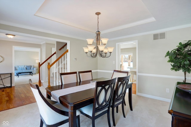 carpeted dining area with crown molding and a notable chandelier