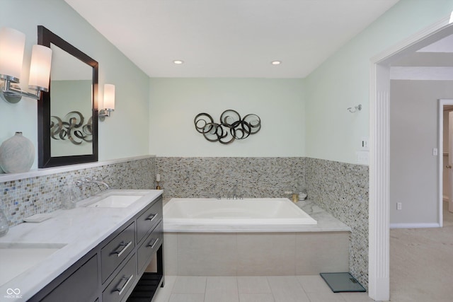 bathroom featuring a relaxing tiled tub, tile patterned floors, and vanity