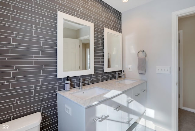 bathroom featuring tile walls, toilet, vanity, and tasteful backsplash