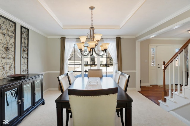 carpeted dining space featuring a raised ceiling, a notable chandelier, and crown molding