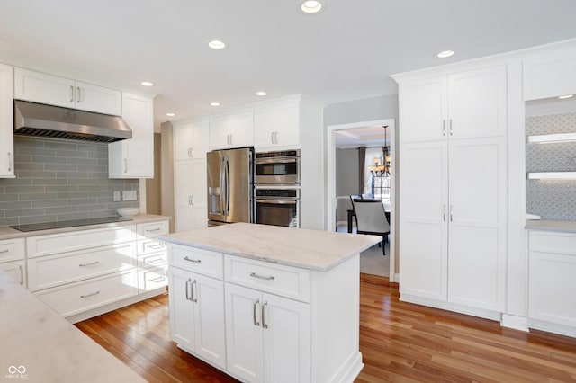 kitchen featuring tasteful backsplash, light wood-type flooring, stainless steel appliances, and white cabinetry