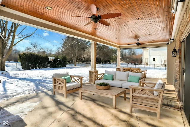 snow covered patio featuring ceiling fan and an outdoor hangout area