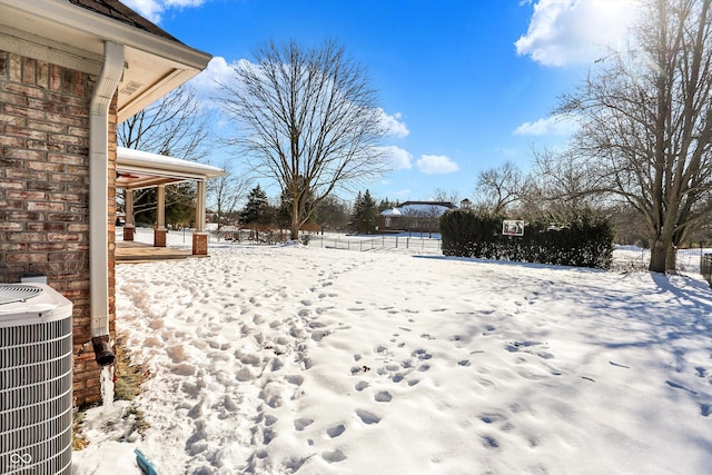 yard layered in snow featuring central air condition unit