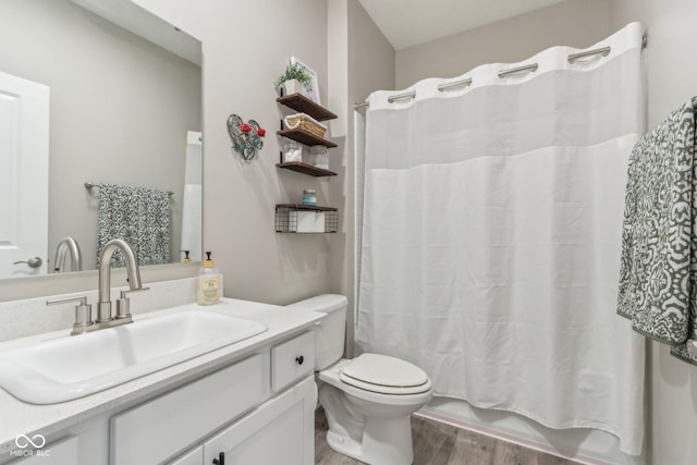 full bathroom with shower / bath combo, hardwood / wood-style floors, vanity, and toilet