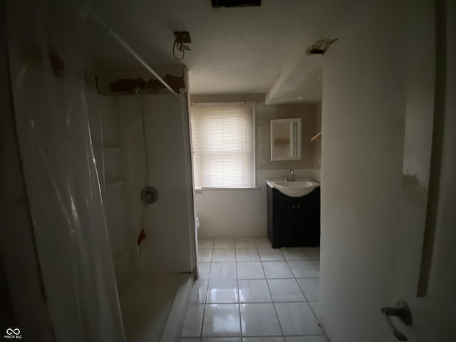 bathroom featuring tile patterned flooring, vanity, toilet, and walk in shower