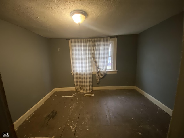 unfurnished room with a textured ceiling