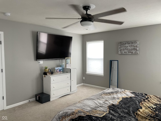 bedroom with ceiling fan and light carpet